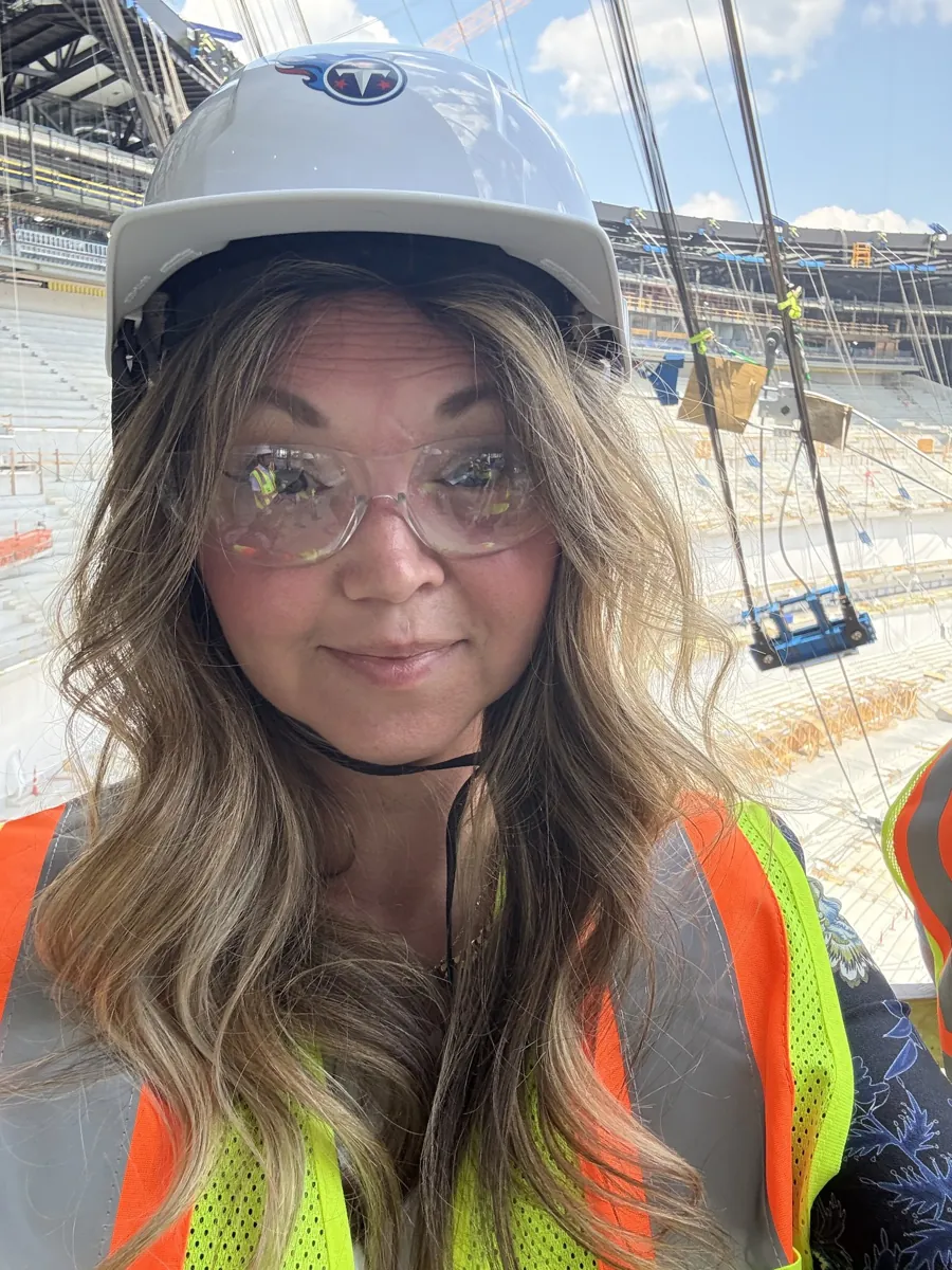 Danielle Lemons in a hard hat at the Titans stadium. Danielle Lemons, Vice President of Operations at DirecTech Connect, in a hard hat and safety vest inside the new Titans stadium under construction in Nashville.