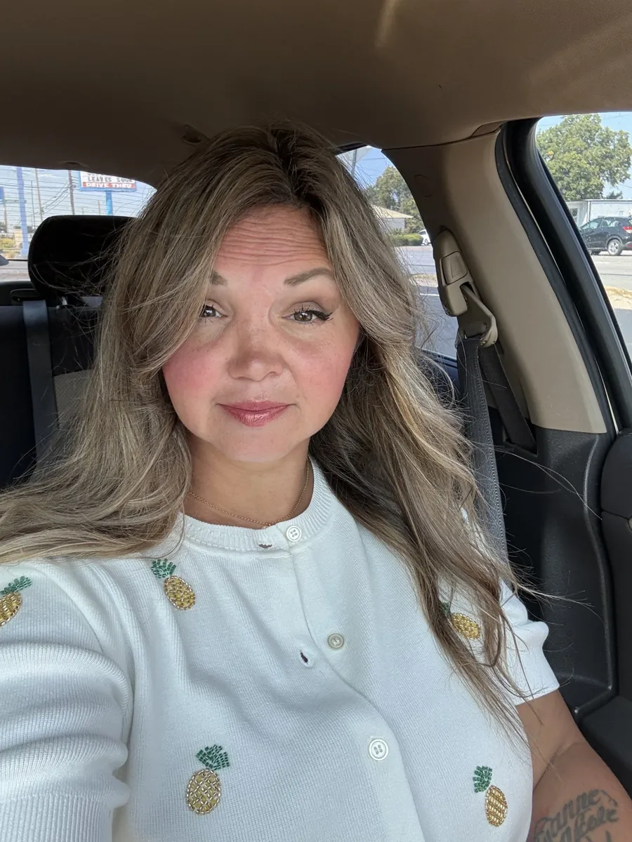 Danielle Lemons in a white cardigan. Danielle Lemons, Vice President of Operations at DirecTech Connect, in a white cardigan with pineapple embroidery.